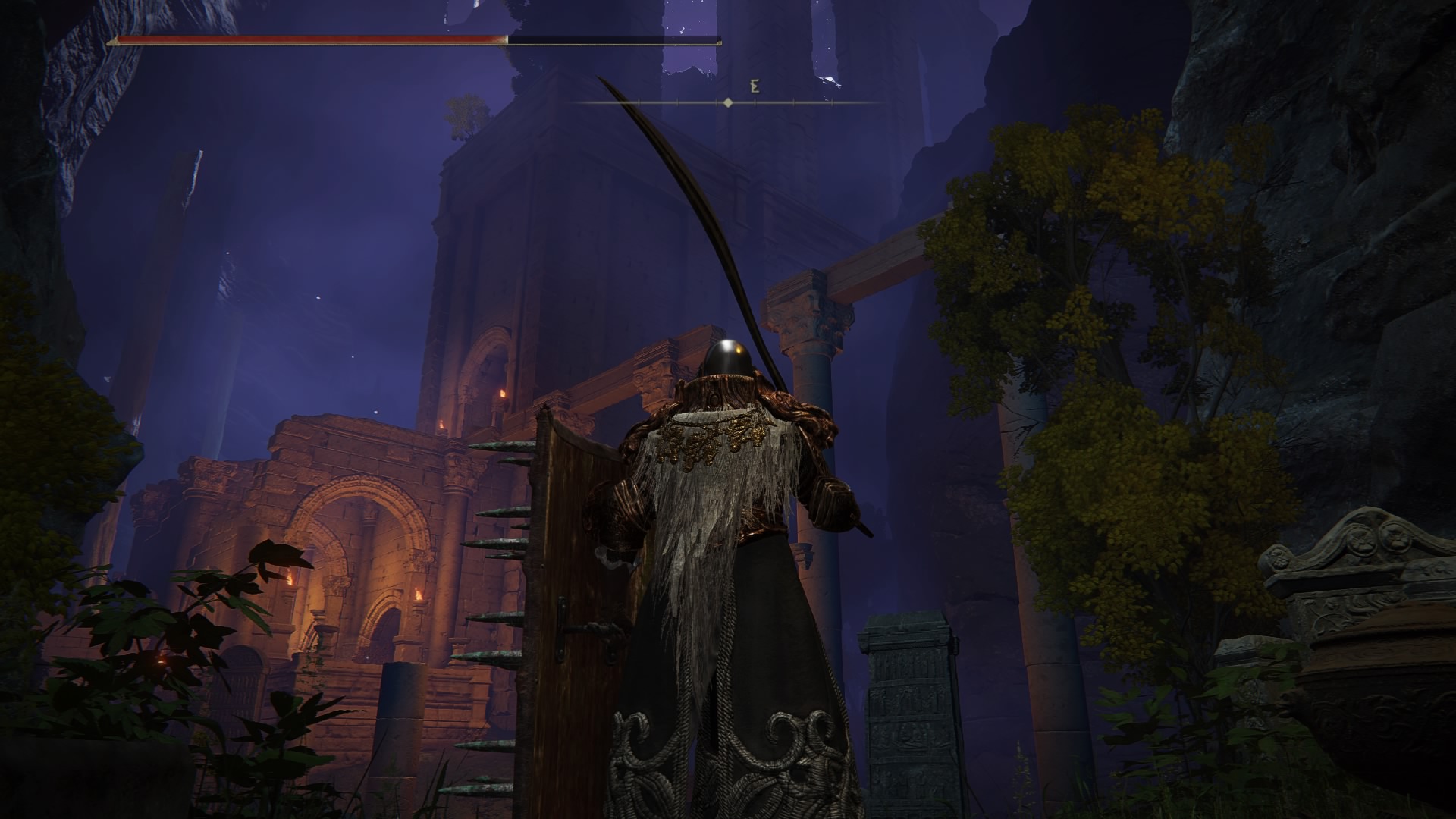 A screenshot of Elden Ring, at the foot of the Siofra River area. There are cliffs streching up all around you, covered in a purple fog. In the distance, torchlit ruins tower up just as high as the cliffs, and the player character tarnished stands in the foreground, holding a long curved sword and a shield covered in spikes.